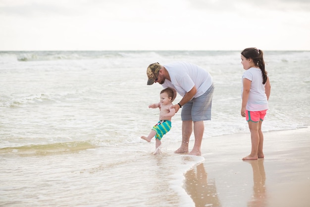 Pai com filhos na praia