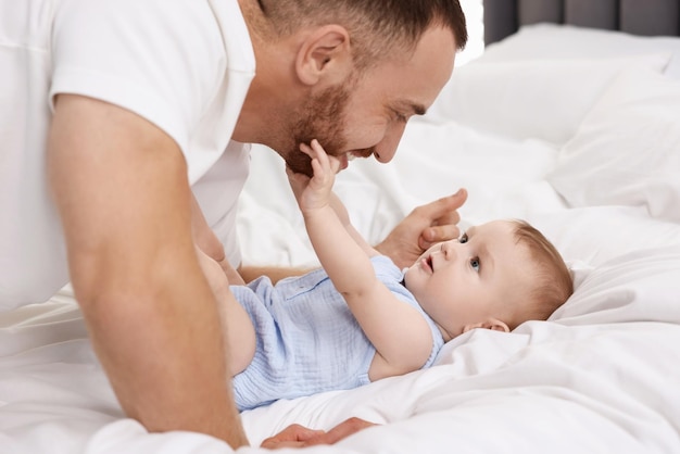 Pai com seu bebê bonito na cama em casa