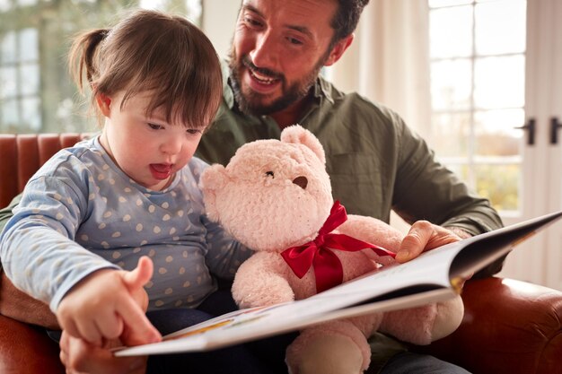 Pai com síndrome de Down filha lendo livro em casa juntos