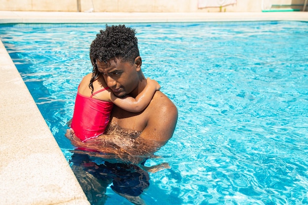 Pai com sua filha triste na piscina