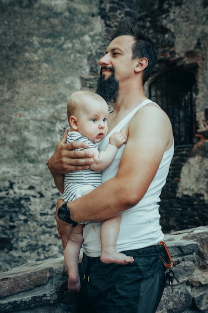 Foto pai com um bebê nos braços contra o pano de fundo de bolhas de sabão e um velho castelo