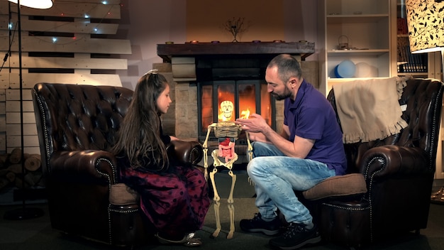 Pai contando a filha sobre a função das costelas no esqueleto humano