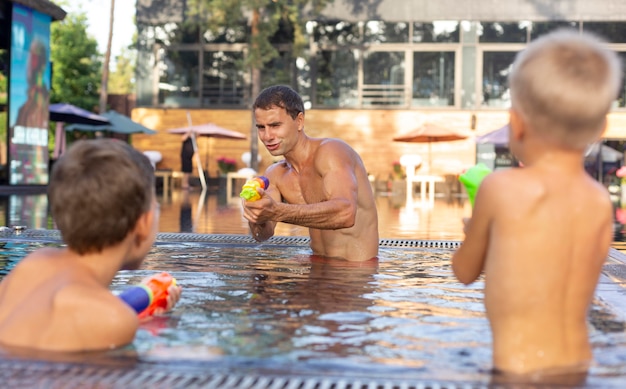Foto pai curtindo um dia com seus filhos na piscina