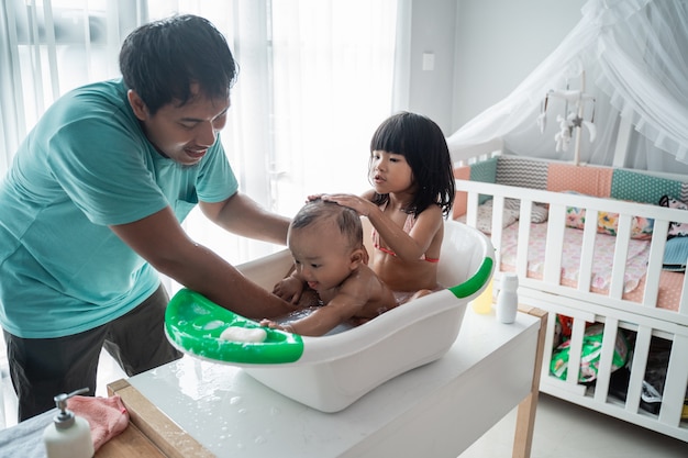 Pai dando banho aos filhos