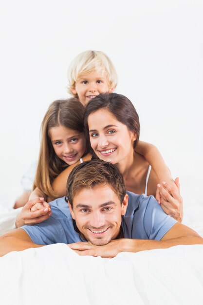 Foto pai dando porquinho de volta para sua família na cama