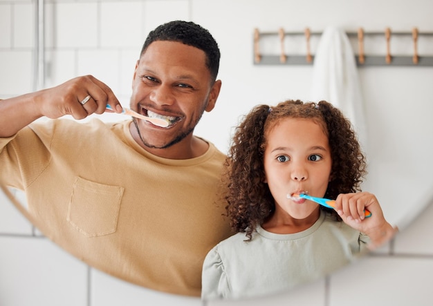 Foto pai de criança e escovar os dentes em um banheiro doméstico familiar para saúde bucal rosto de homem africano feliz e criança aprendendo a limpar a boca com escova de dentes no espelho para rotina matinal ou higiene bucal