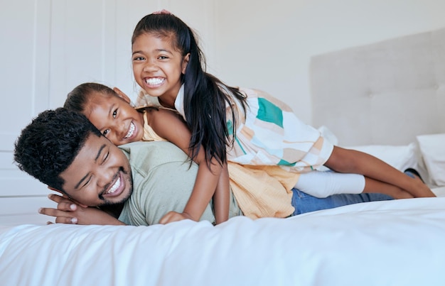 Foto pai de família feliz e filhas na cama em casa com retrato de sorriso pai e filhos brincam juntos na ásia diversão amorosa e tempo para a família para pai e filhas no quarto em casa de família na indonésia