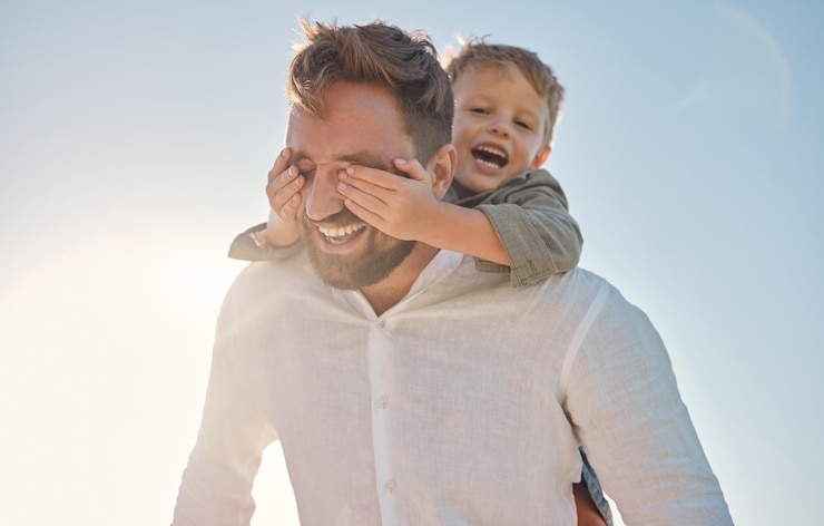 Foto pai de família feliz e mãos de criança cobrindo os olhos de pais em uma praia no verão brincando e se divertindo com adivinhação e jogo surpresa mão de família e criança fechando o olho do pai enquanto caminhava de férias