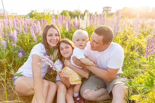 pai de mãe de família feliz abraçando crianças ao ar livre. mãe, pai e filhas brincando no campo ao ar livre