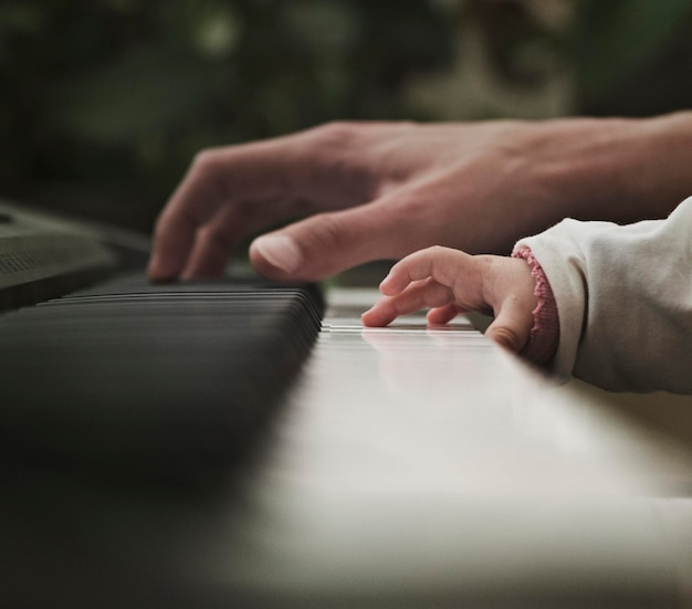 Foto pai e bebé a tocar piano