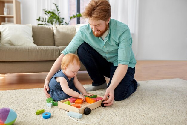 pai e bebê brincando com blocos de brinquedo em casa