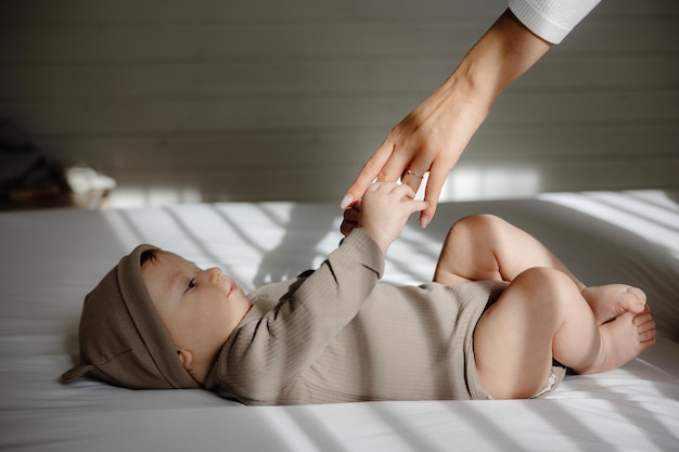 pai e bebê, um bebê está segurando a mão de sua mãe na cama