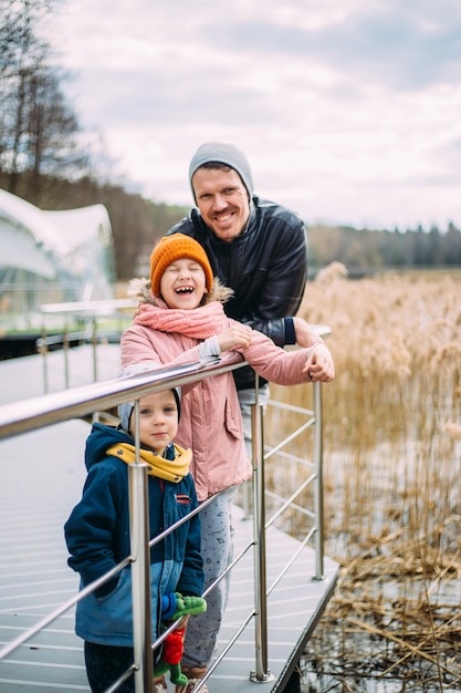 Pai e dois filhos caminham na natureza no outono passam tempo juntos se divertem