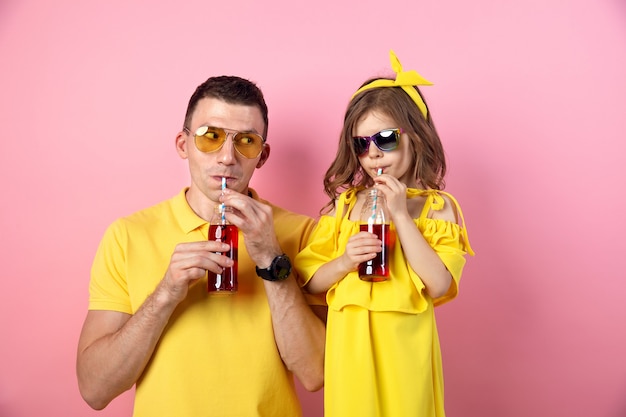 Pai e filha bebendo bebidas vermelhas e sorrindo
