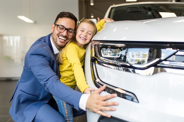 Pai e filha comprando um carro novo no showroom de carros.