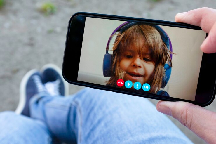 Foto pai e filha conversando entre si através de uma chamada de vídeo em um smartphone mão segurando um smartphone com um rosto de menina relacionamento à distância conceito de infância pai divorciado