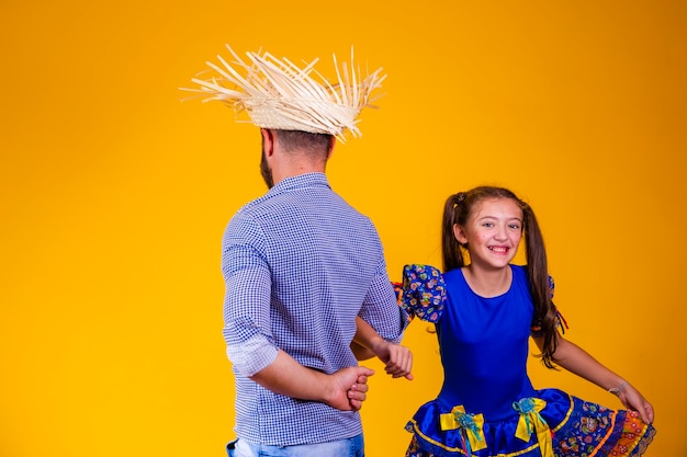 Foto pai e filha dançando quadrilha na festa junina celebração junina pai e filha com fantasia da festa junina