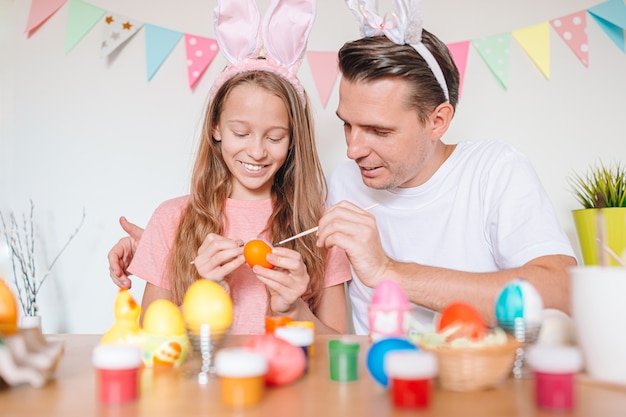 Pai e filha dele pintando ovos. Família feliz, preparando-se para a Páscoa.