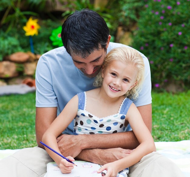 Pai e filha desenhando em um parque