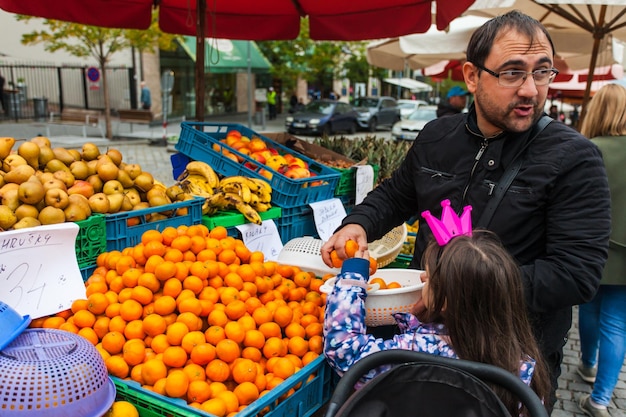 Pai e filha escolhem tangerinas.