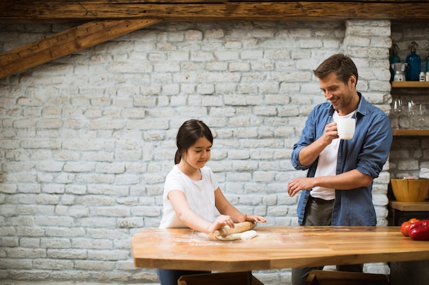 Pai e filha fazendo pão na cozinha rústica