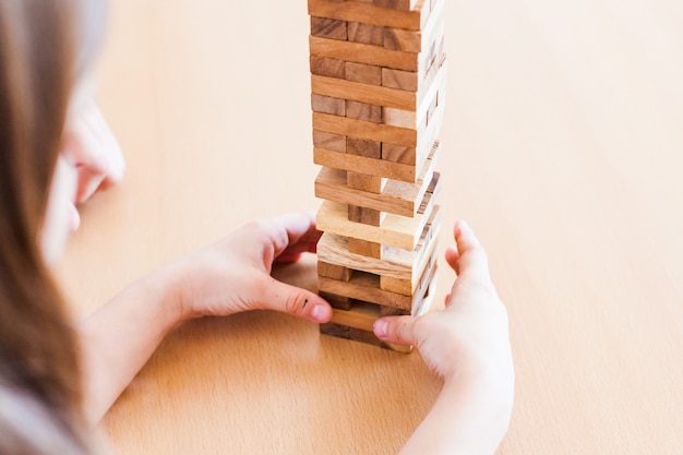 Pai e filha jogam em casa, custam uma torre de blocos, cubos, quebra-cabeças para o desenvolvimento do cérebro, inteligência mental