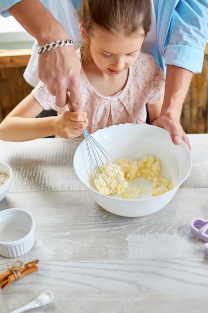 Pai e filha juntos a preparar massa na cozinha