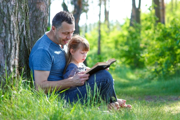 Pai e filha lendo livro bíblico