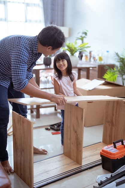 Pai e filha montando móveis de automontagem