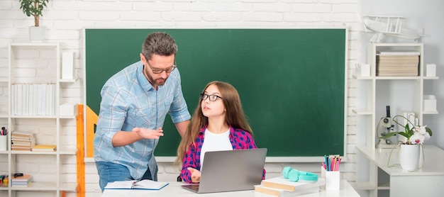 Pai e filha no banner de professor e aluno concentrado pai e filho estudam na escola com laptop na infância de fundo de quadro-negro