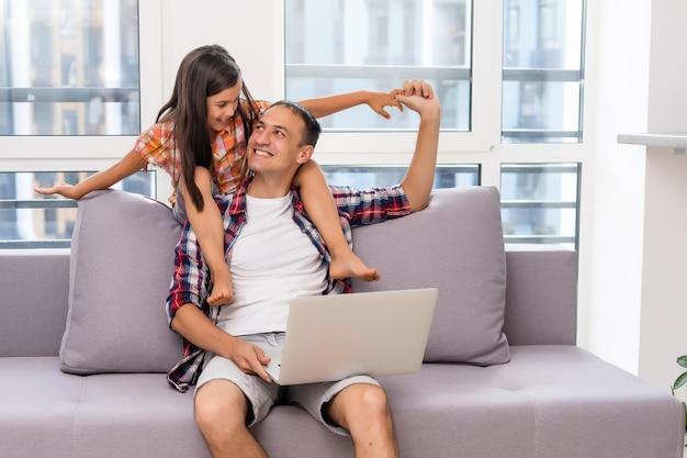 Pai e filha rindo no laptop