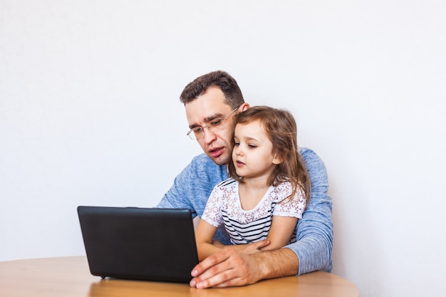 Pai e filha se comunicam pela Internet com seus parentes