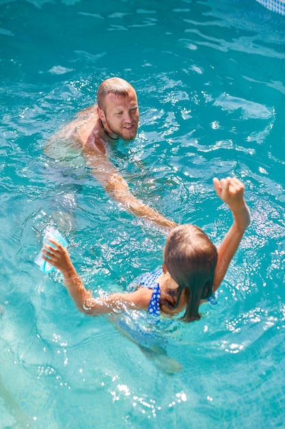 Pai e filha se divertem na piscina em casa