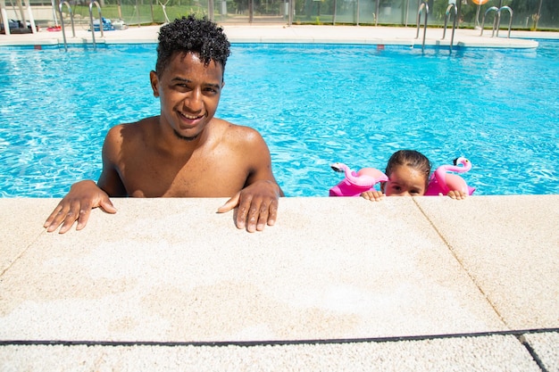 Pai e filha se divertindo na piscina