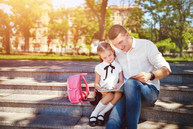 Pai e filha sentada na escada e ler livro