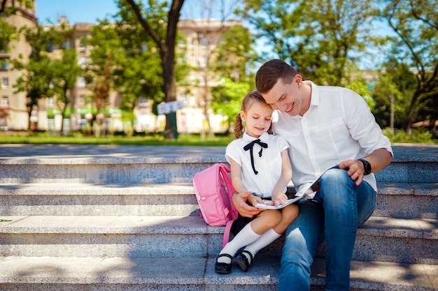 Pai e filha sentada na escada e ler livro