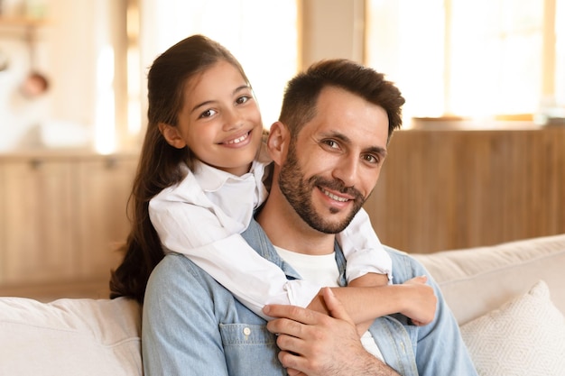 Pai e filha sorrindo para a câmera