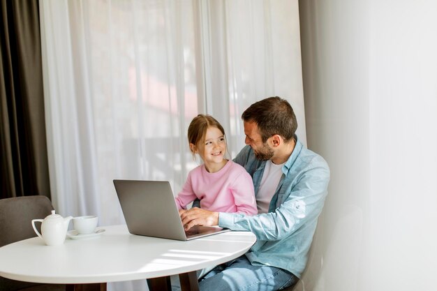 Pai e filha usando laptop juntos