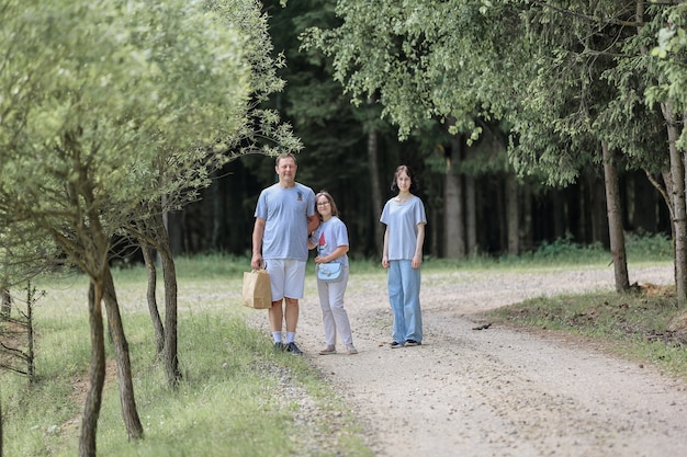 Pai e filhas em uma caminhada na floresta de verão