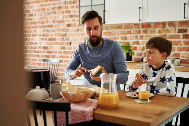 Pai e filho a tomar o pequeno-almoço em casa.