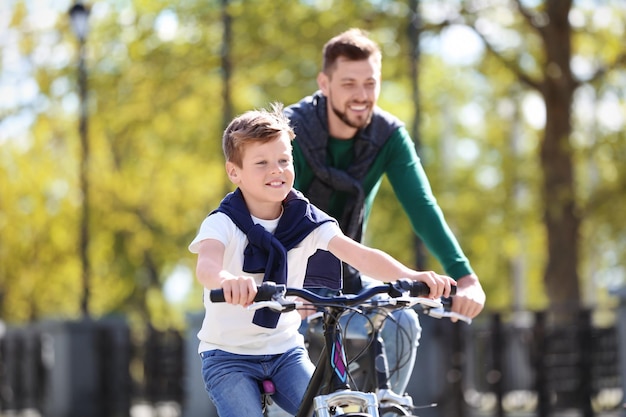 Foto pai e filho andando de bicicleta ao ar livre