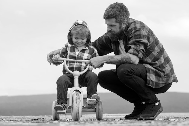 Pai e filho andando de bicicleta com crianças de bicicleta ao ar livre