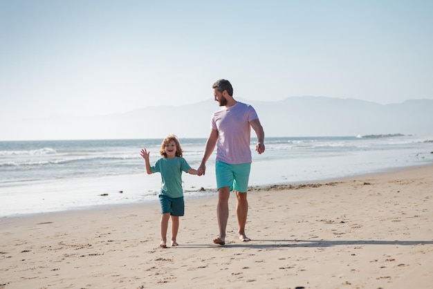 Pai e filho andando no mar Pai e filho de mãos dadas e caminham juntos