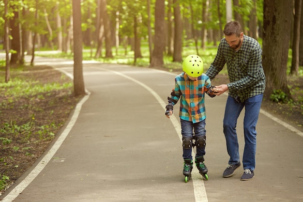 Pai e filho ao ar livre, preparando-se para patinar