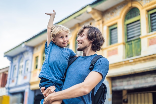 Pai e filho ao fundo de Casas antigas na cidade velha de Georgetown, Penang, Malásia