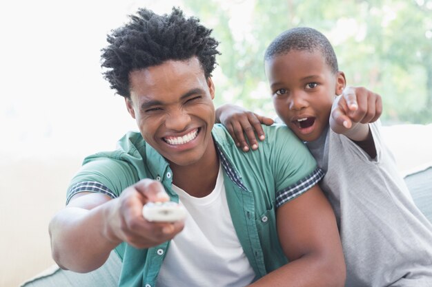 Pai e filho assistindo televisão juntos no sofá