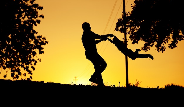 Pai e filho brincando ao pôr do sol