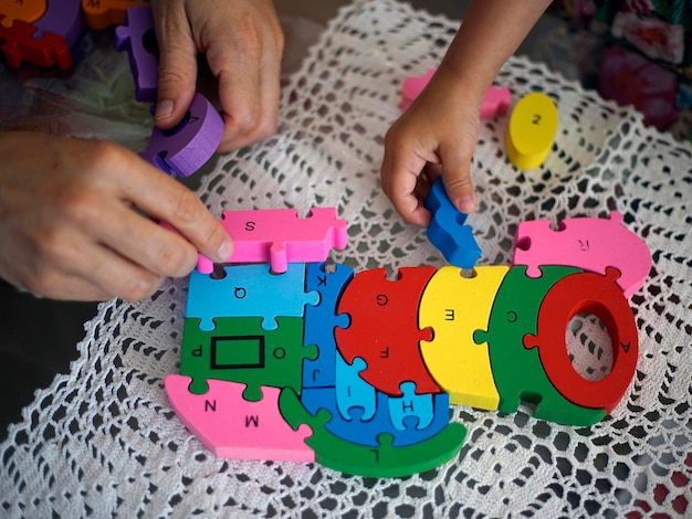 Pai e filho brincando com brinquedos educativos empilhando e organizando peças coloridas com letras Aprendendo através do conceito de experiência