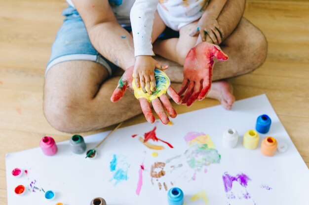 Pai e filho brincando com cores de tinta