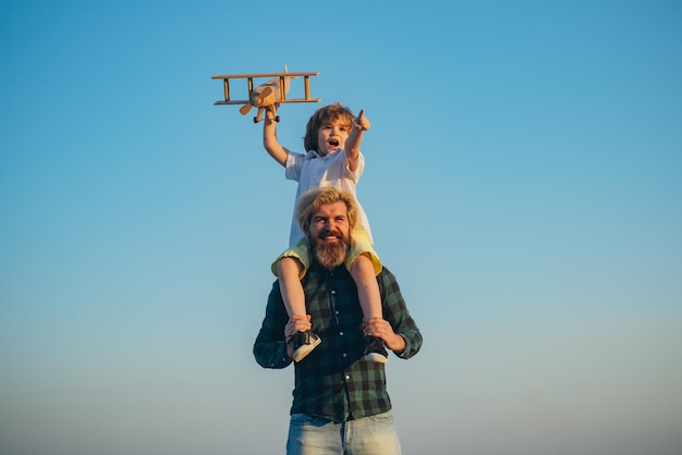 Pai e filho brincando com o avião de brinquedo ao ar livre. Férias em família, paternidade. Dia dos Pais. Menino feliz.